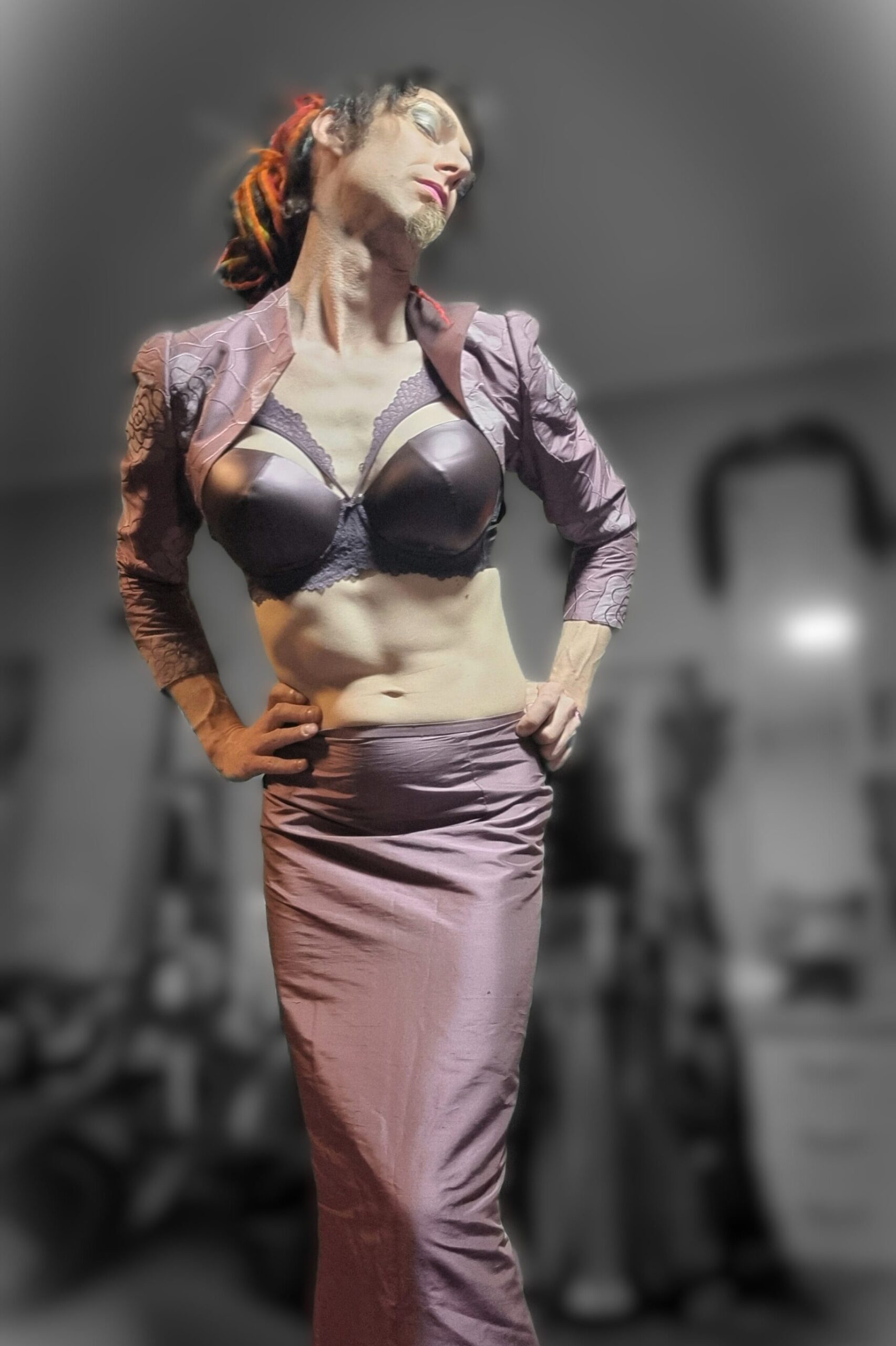Jasmine Dlight in a statuesque pose wearing a satin plum mermaid skirt and bra, exuding glamour, poise, and femme power.