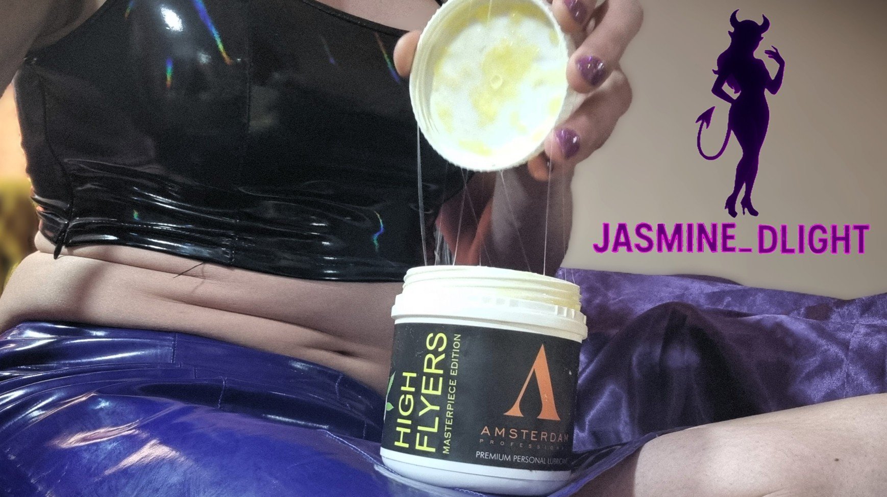 Jasmine_Dlight opens a tub of Amsterdam Professional High Flyers lube, showing its thick, glossy texture — perfect for extreme anal play.